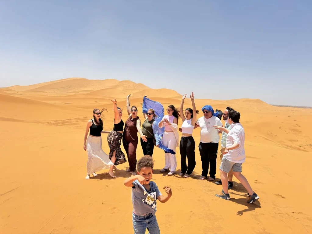Travellers celebrating on the dunes at Erg Chebbi