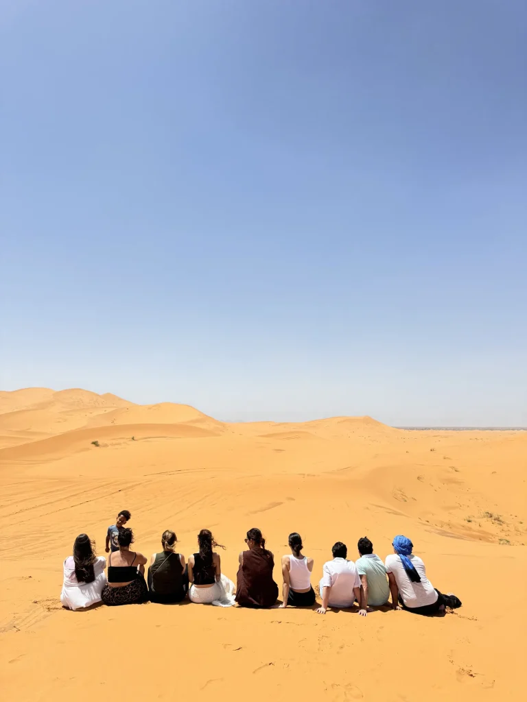 Group sitting on a dune looking out over Erg Chebbi